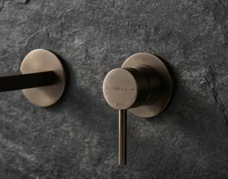 Aria flush plate in brushed bronze on ceramic slab wall